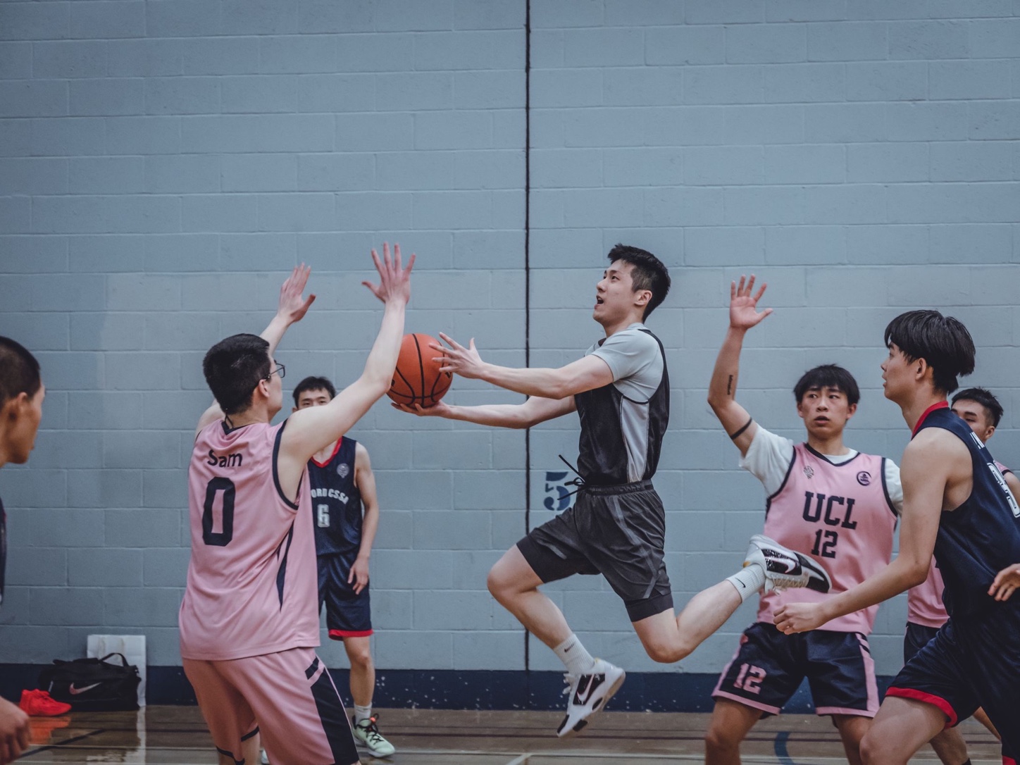 Basketball players wearing contrasting jerseys during an indoor game